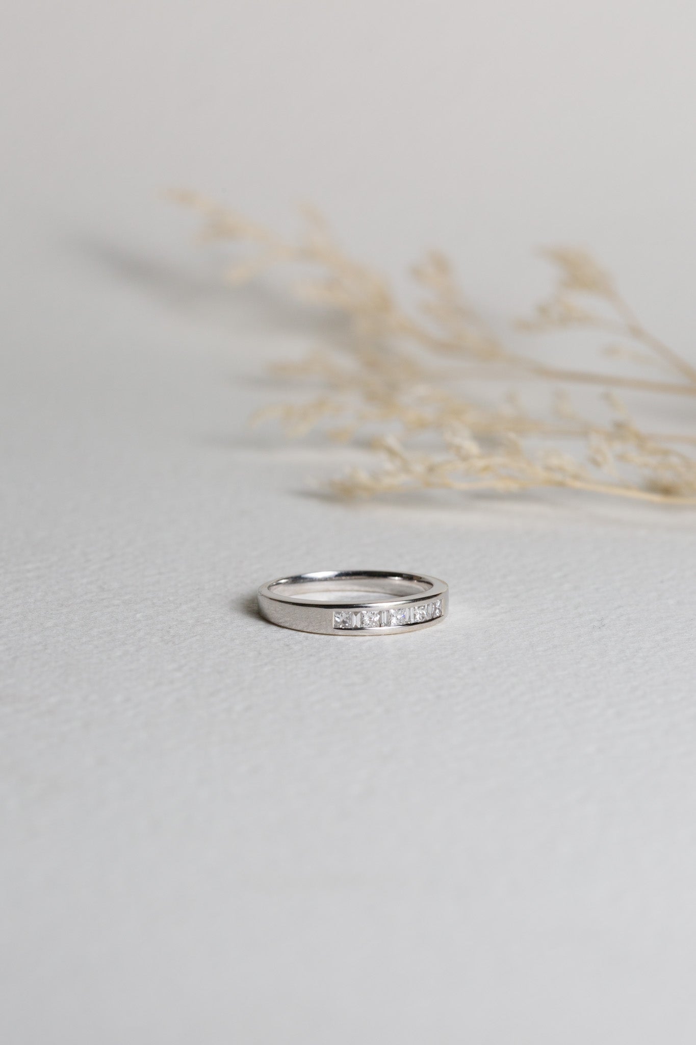 White gold wedding band with princess cut diamonds set into a channel