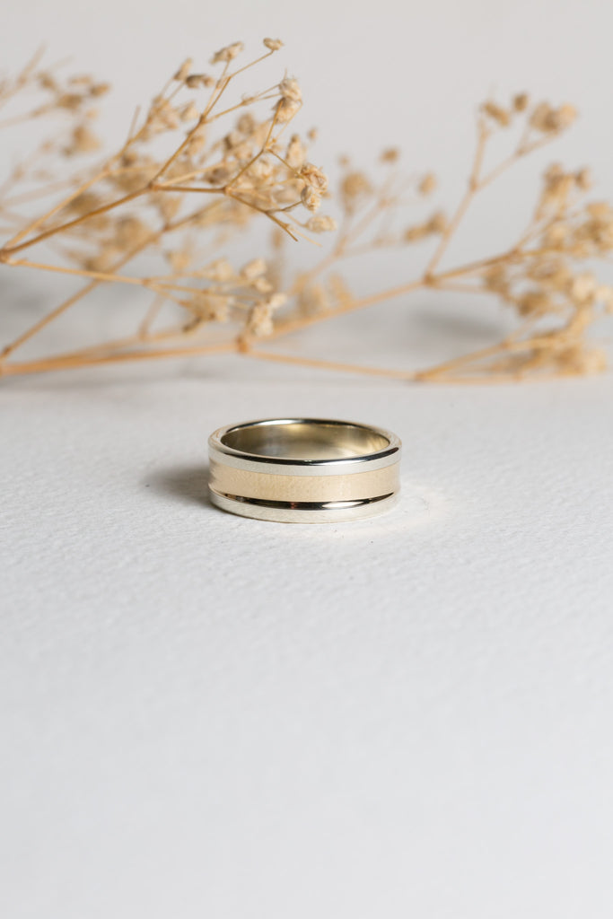 Mens modern wedding ring.  It has both white and yellow gold.