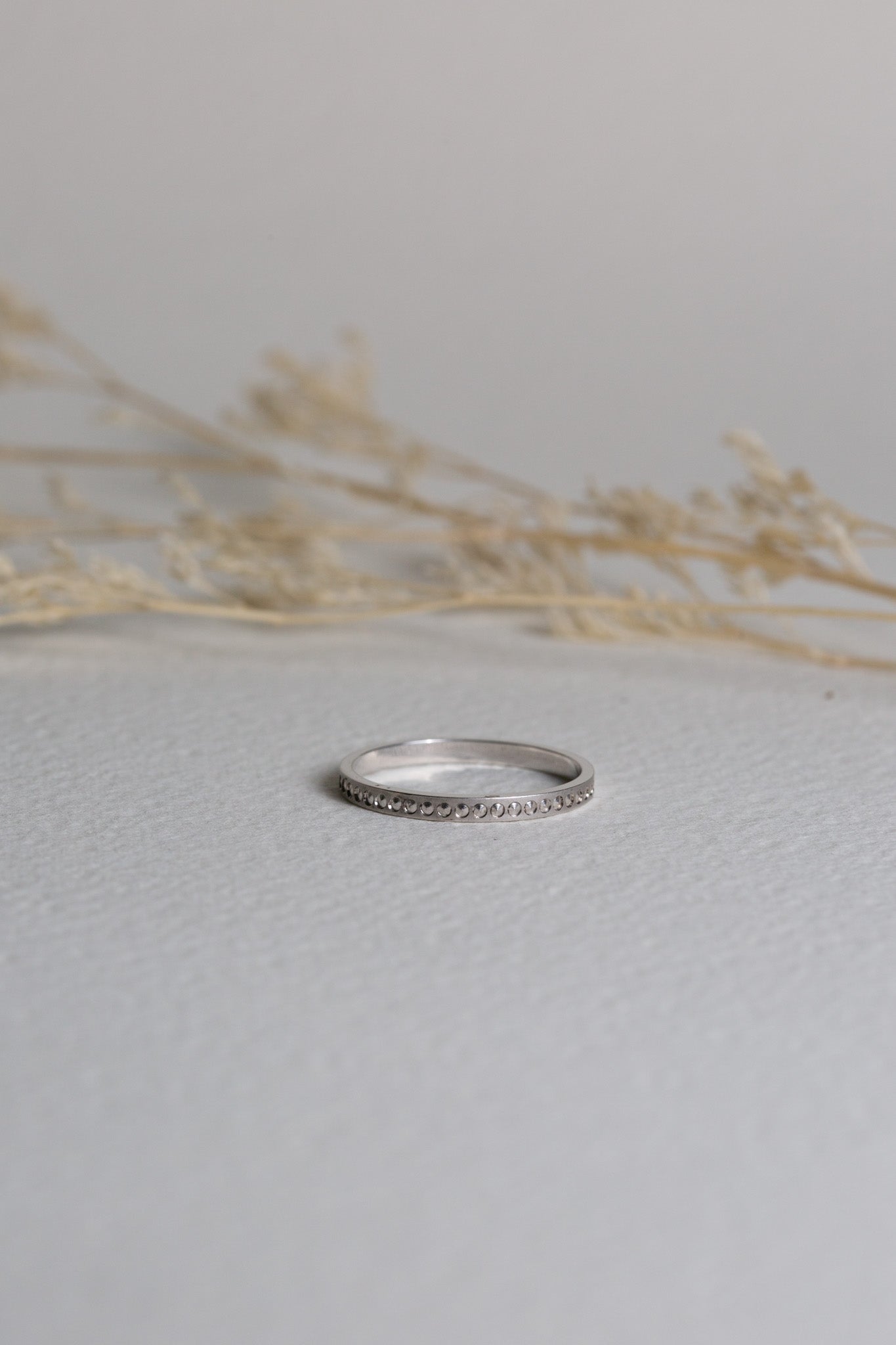 White gold ladies ring with patterns around it