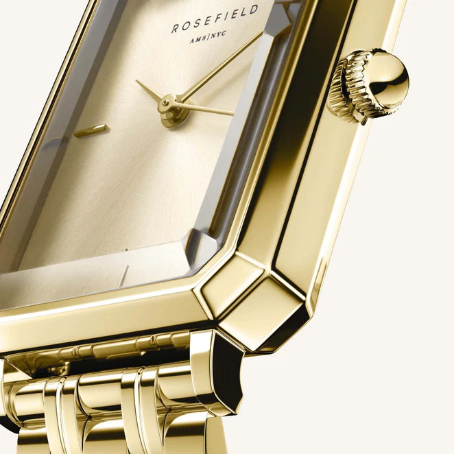 Close up view of a gold ladies watch with a faceted glass
