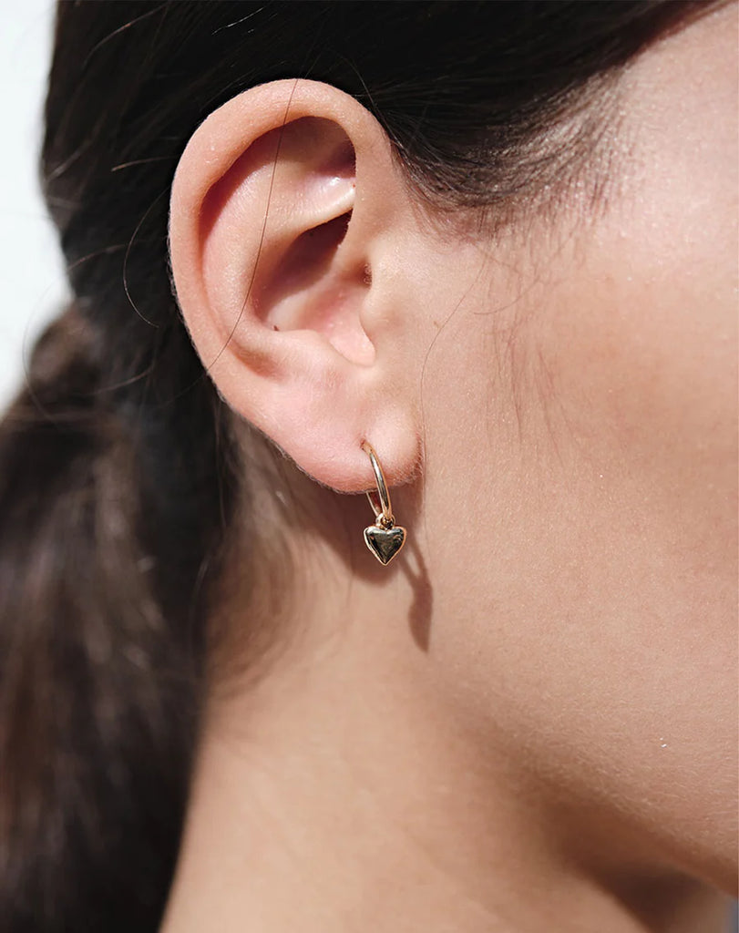 Silver heart hoop earrings shown on model