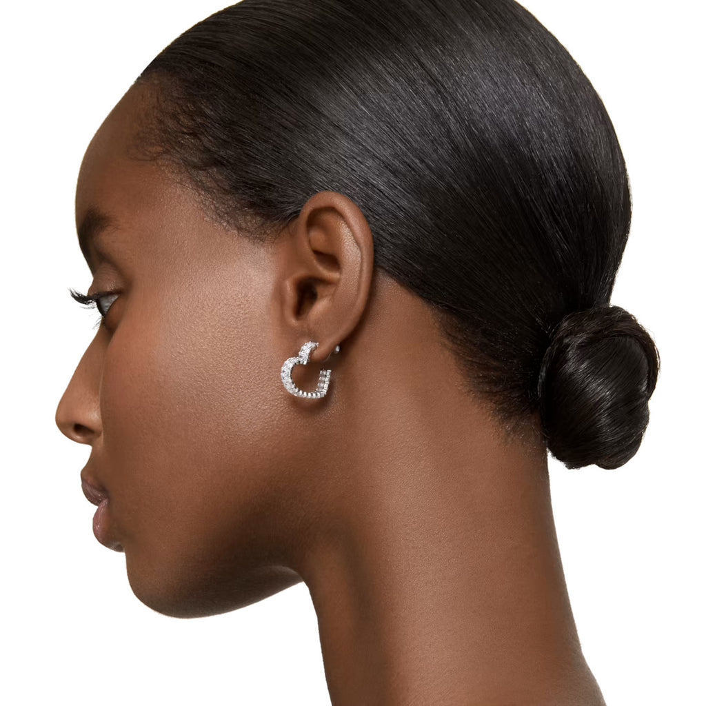 A model is wearing a pair of heart hoop Swarovski crystal earrings