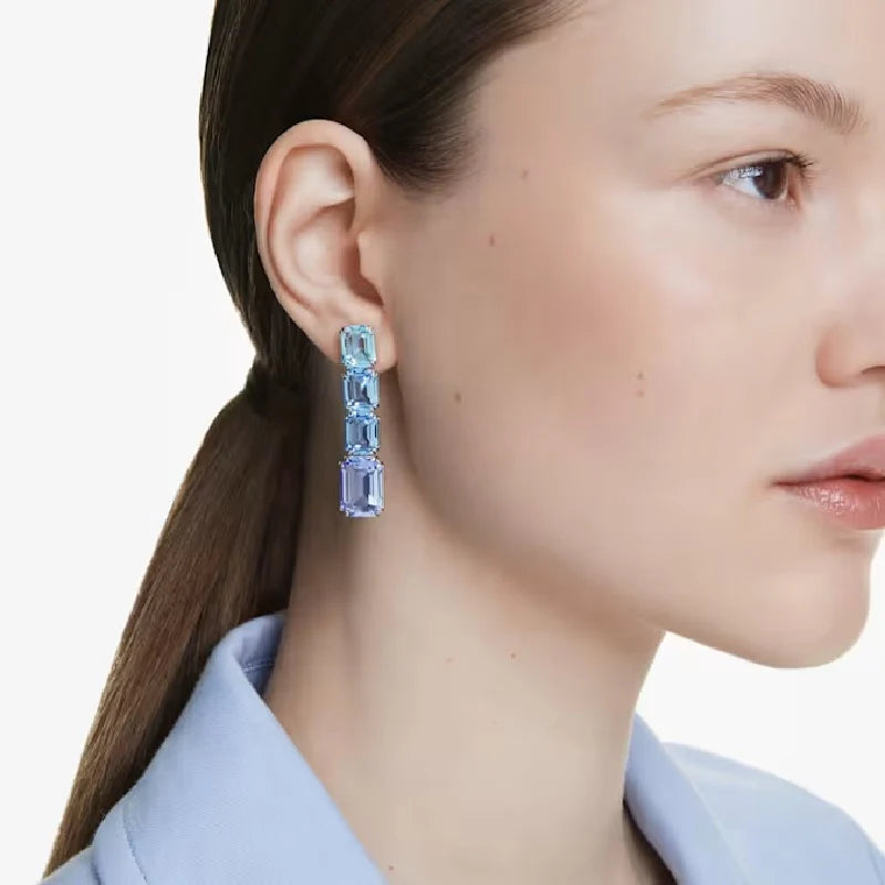 A model is wearing blue Swarovski crystal drop earrings