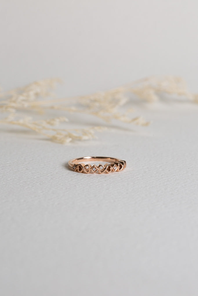 Rose gold ring with infinity symbols around it