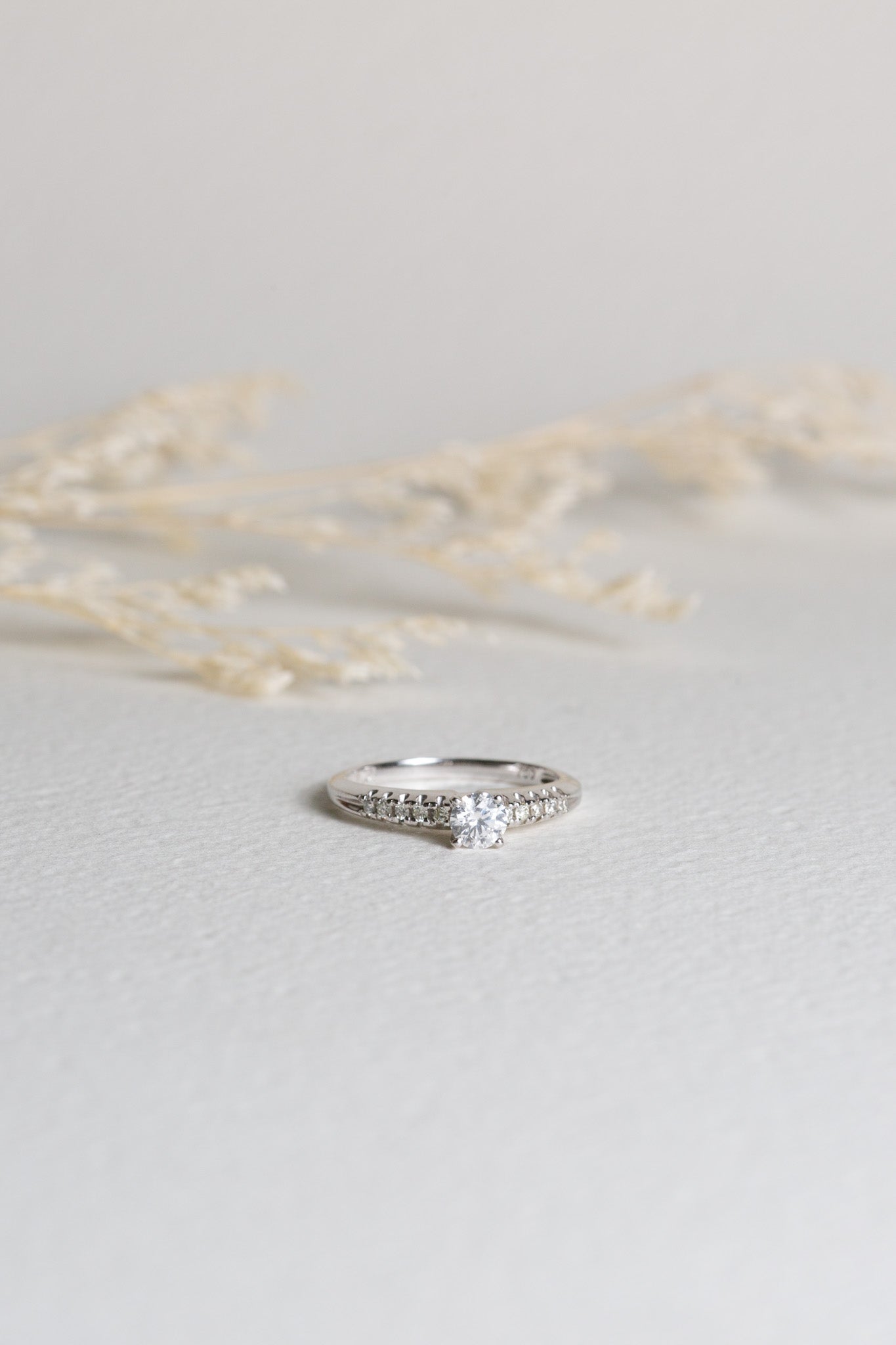 White gold diamond engagement ring with diamonds set on the shoulders
