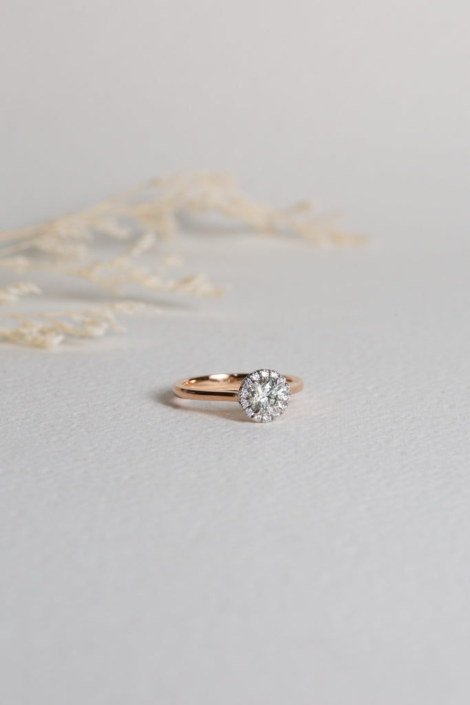 Rose gold diamond engagement ring set with a centre diamond and a halo of diamonds