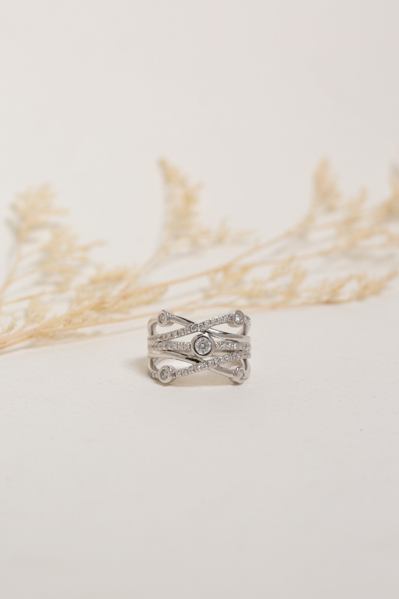 Wide white gold diamond dress ring.  The ring has large bezel-set diamonds and smaller claw-set diamonds.