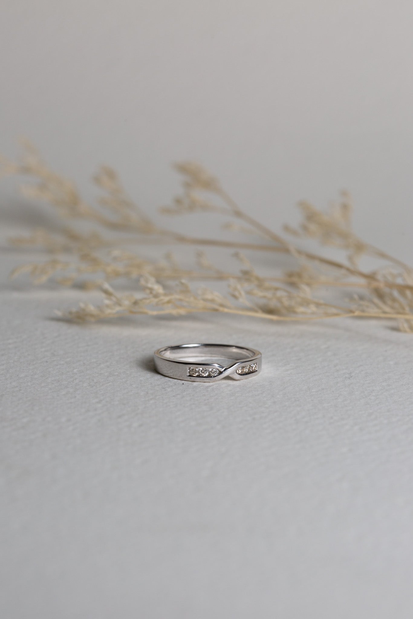 White gold diamond wedding ring with a cross-over design to sit against an engagement ring