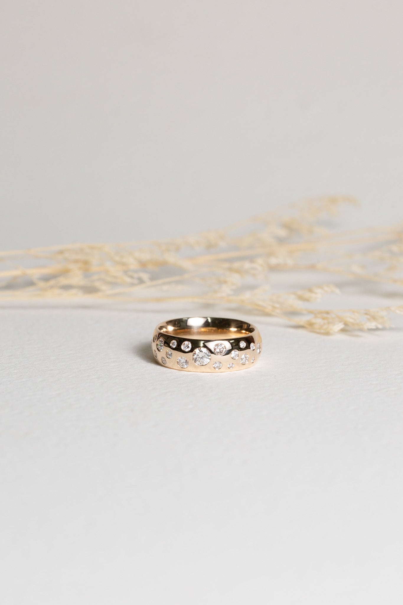 Wide gold ring, set with scattered diamonds of different sizes