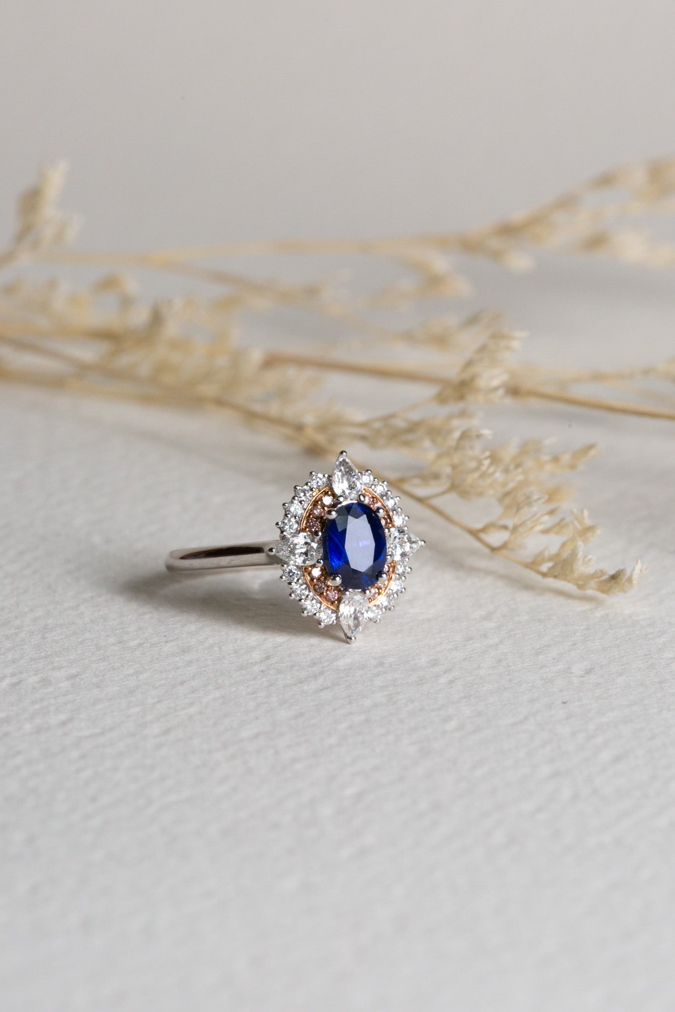 Cocktail ring set with a vibrant blue sapphire, pink diamonds, and white diamonds