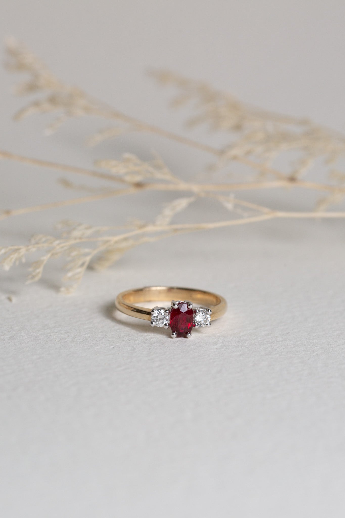 9ct Gold ring with an oval-cut Ruby in the centre, and diamonds either side