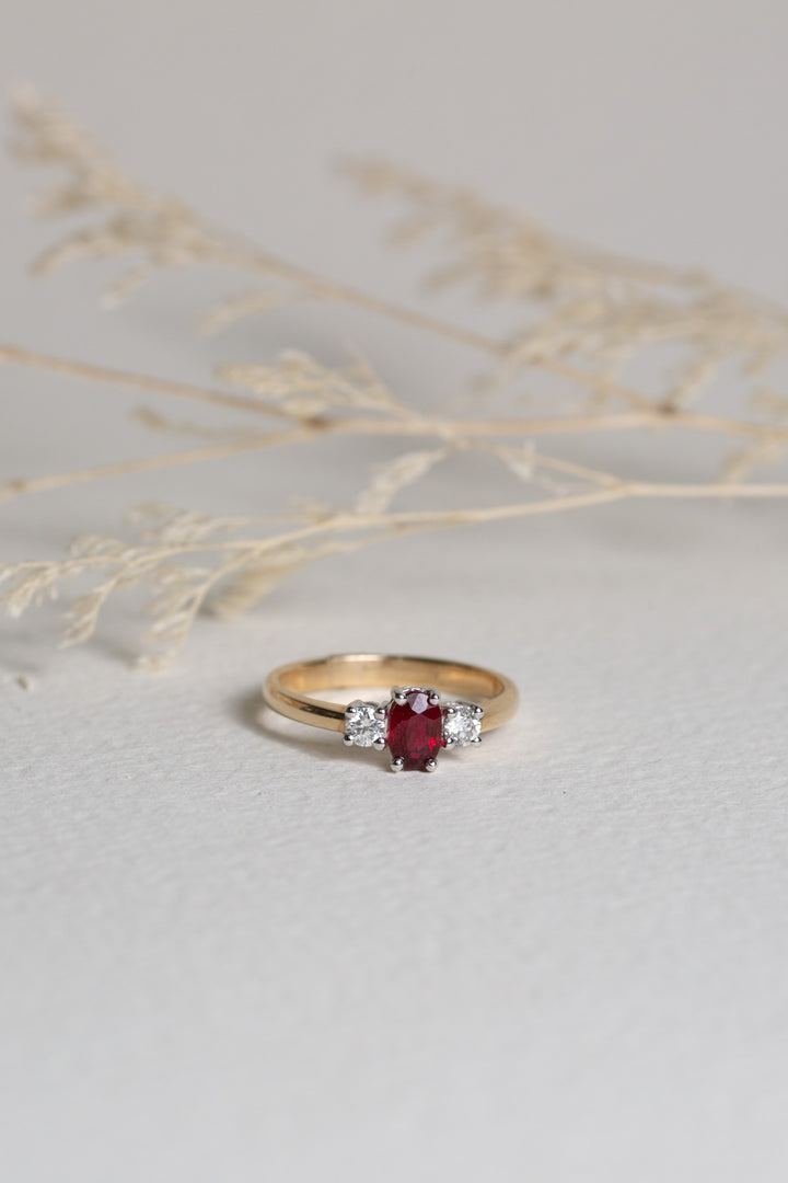 9ct Gold ring with an oval-cut Ruby in the centre, and diamonds either side