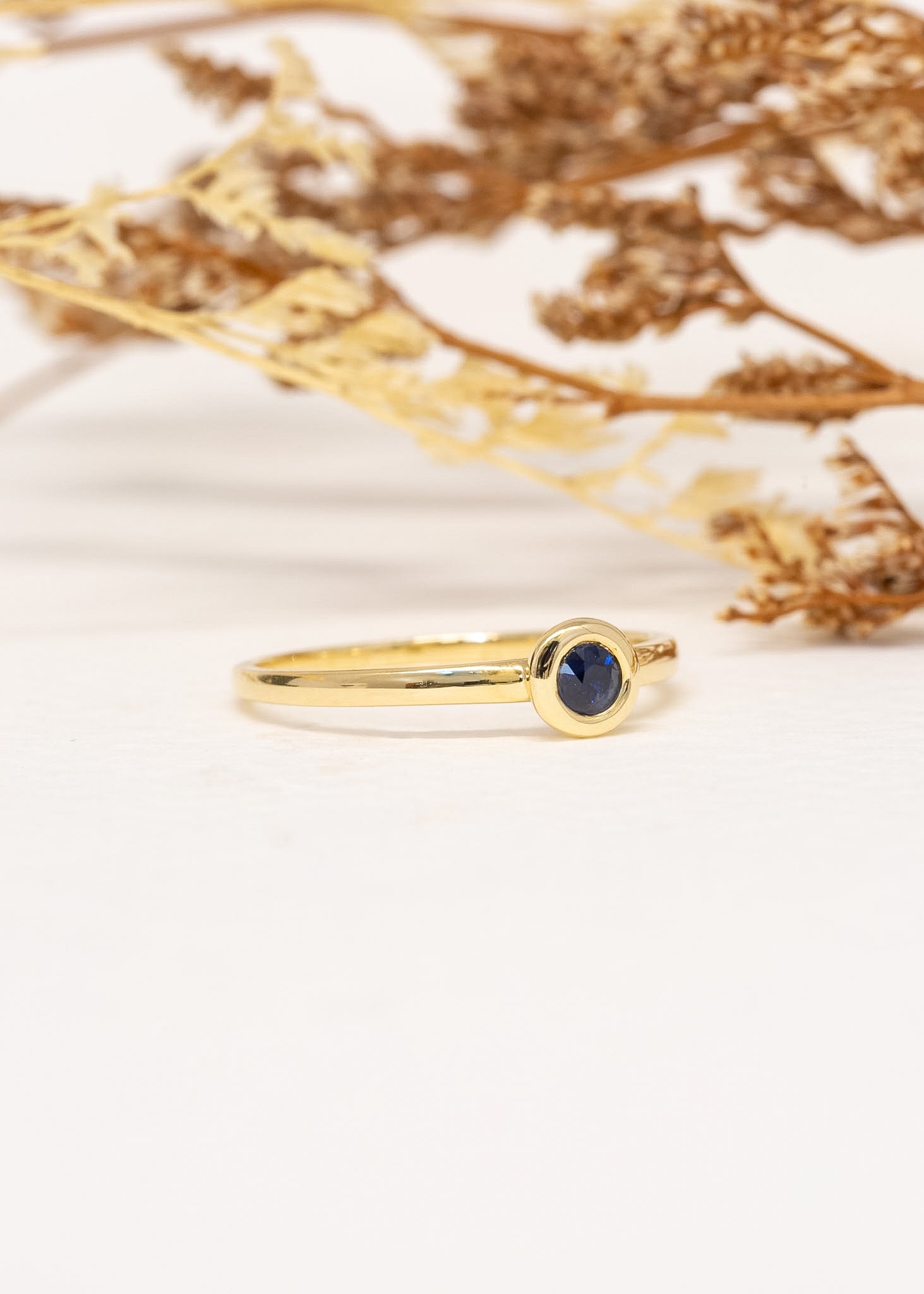 Solis Sapphire Ring in 9ct yellow gold, styled with dried foliage