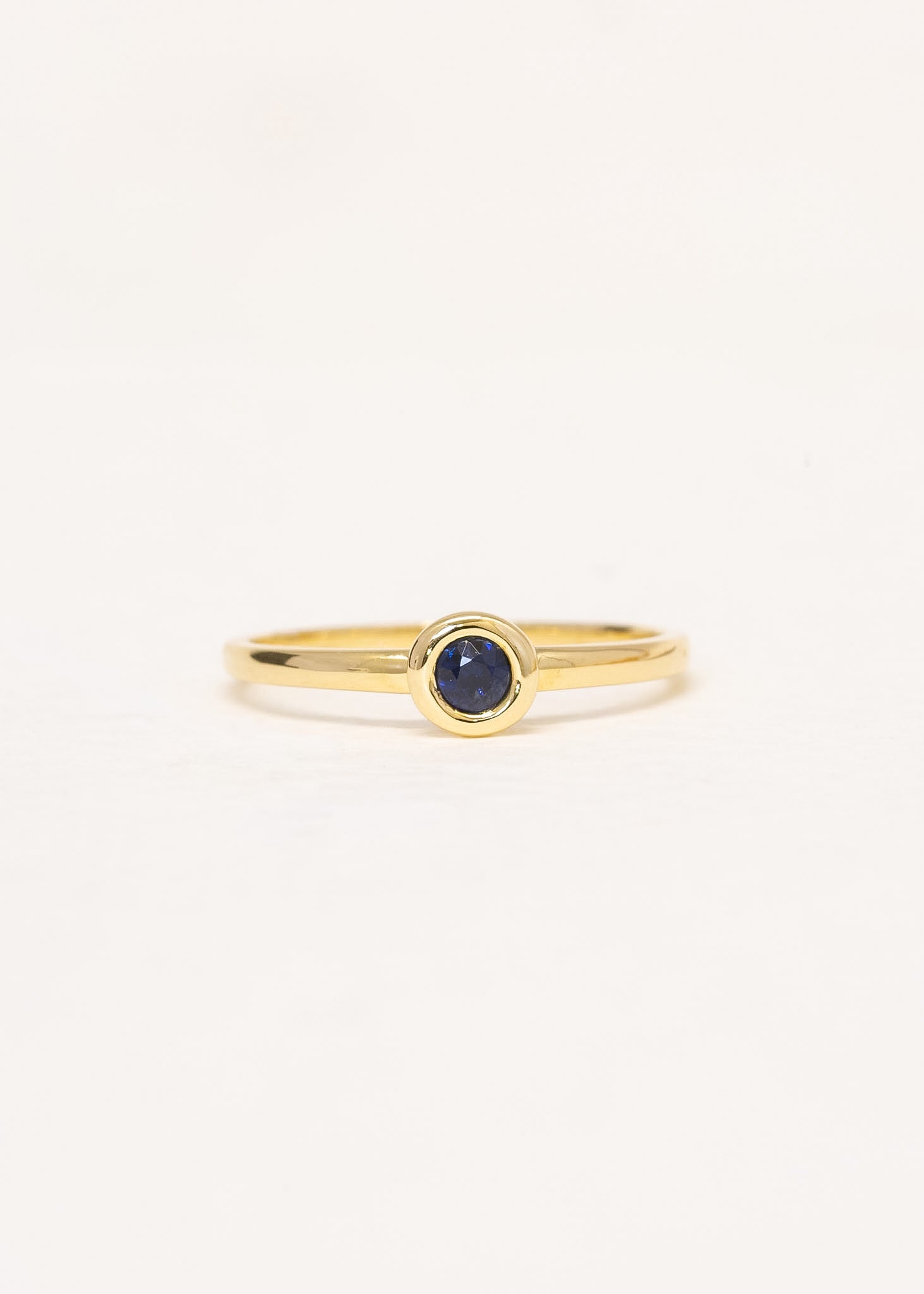 Close-up of Solis Sapphire Ring showing bezel-set blue sapphire in 9ct yellow gold