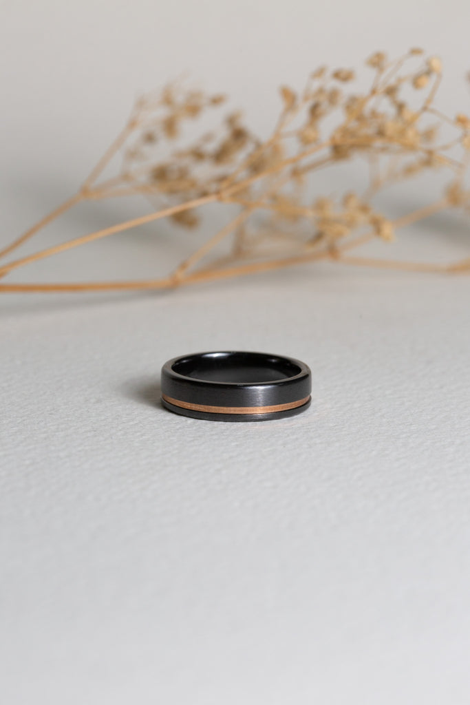 Mens black zirconium wedding ring with a rose gold inlay