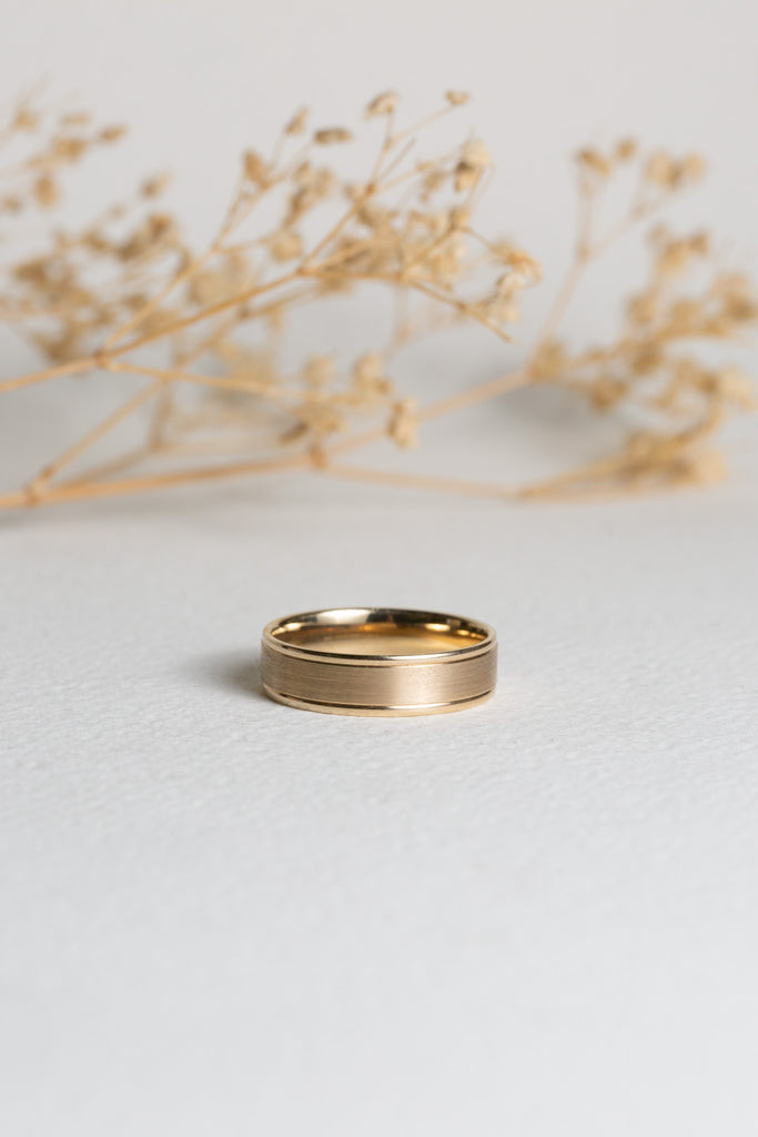 Mens gold wedding band with a textured centre