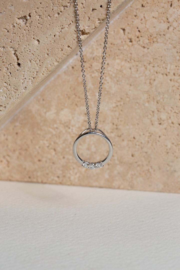 White gold circle pendant set with three diamonds