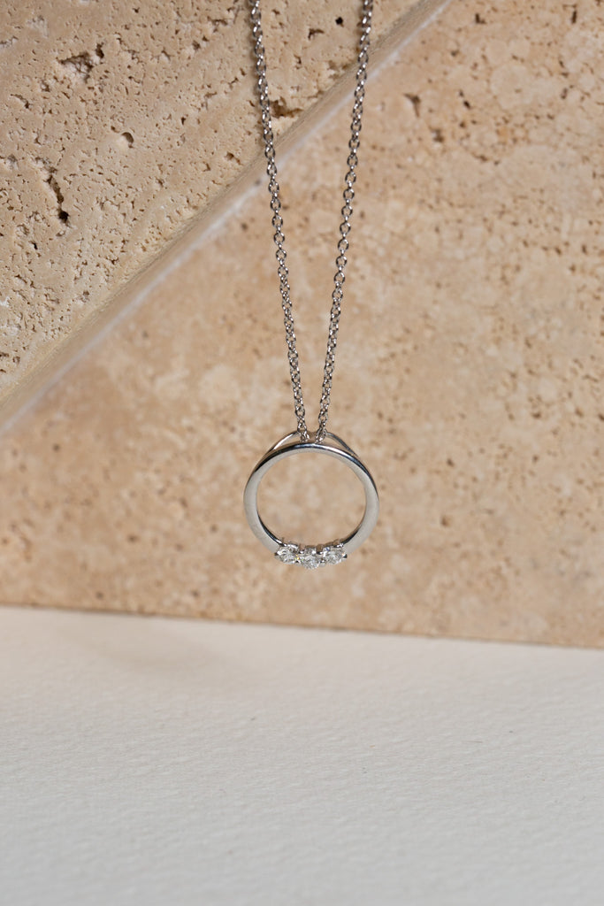 White gold circle pendant set with three diamonds