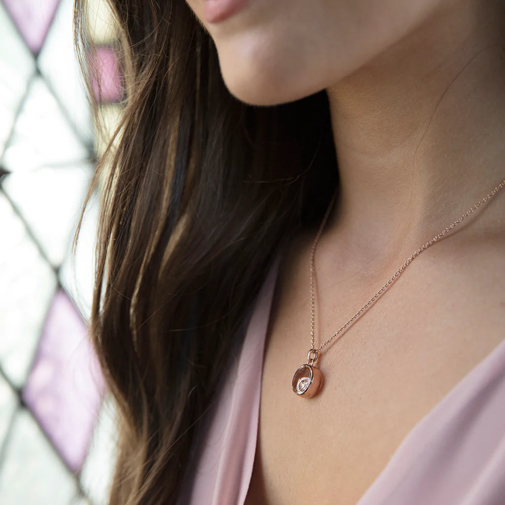 Rose gold petite locket worn by a model