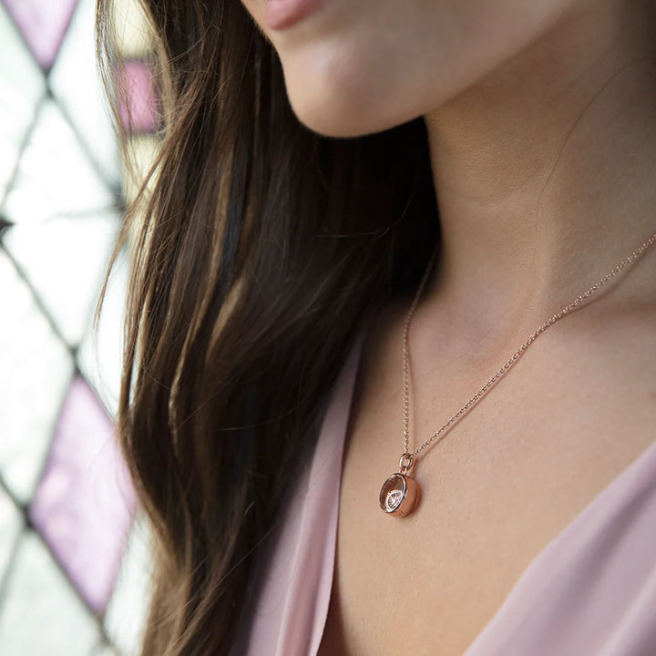 Rose gold petite locket worn by a model