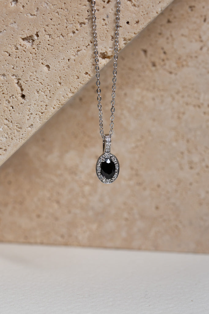 White gold necklace with a sapphire and diamond halo pendant
