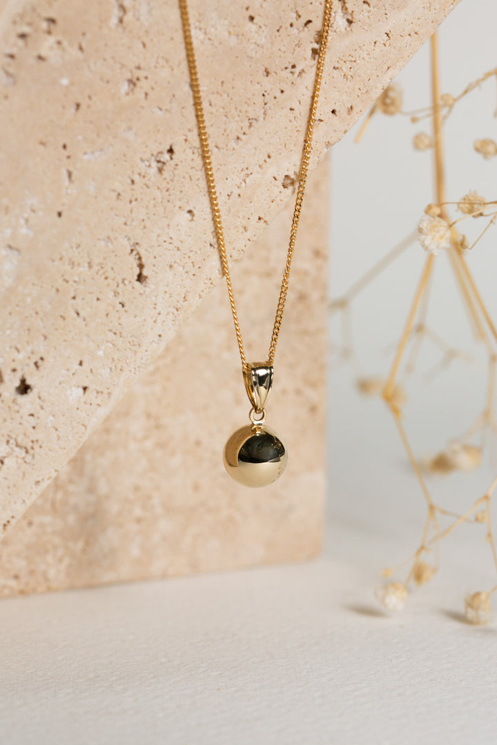 gold full ball pendant on a chain