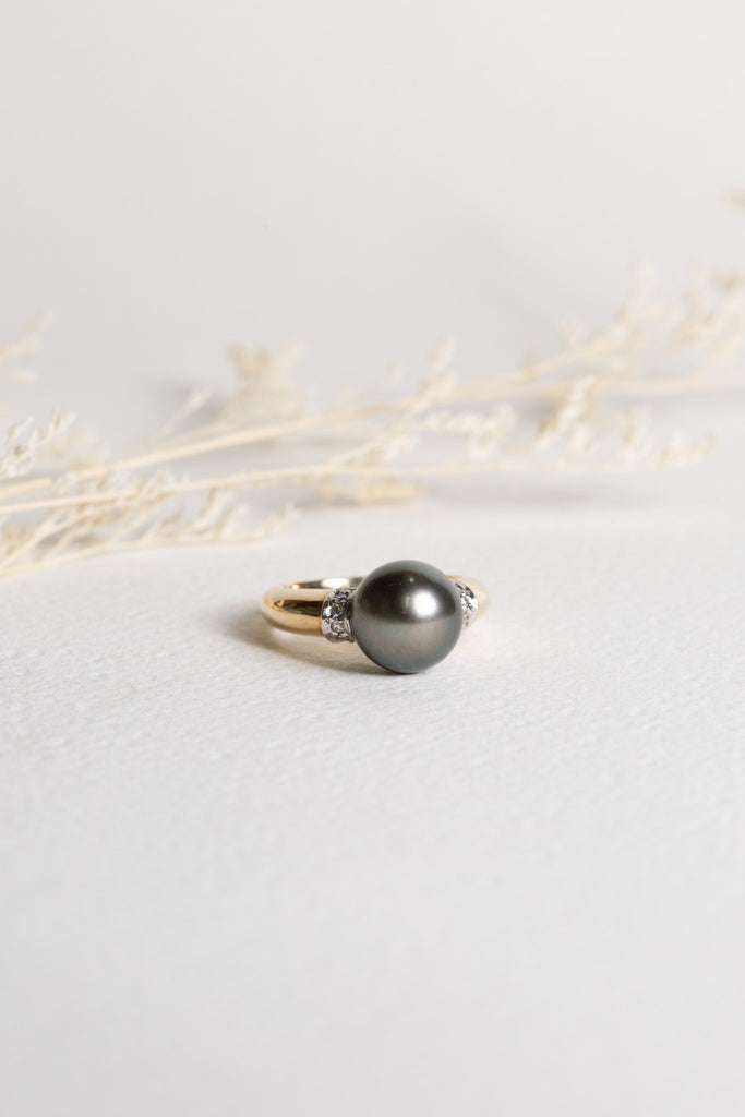 Pearl and diamond ring, set in gold.  The pearl is a large black pearl.