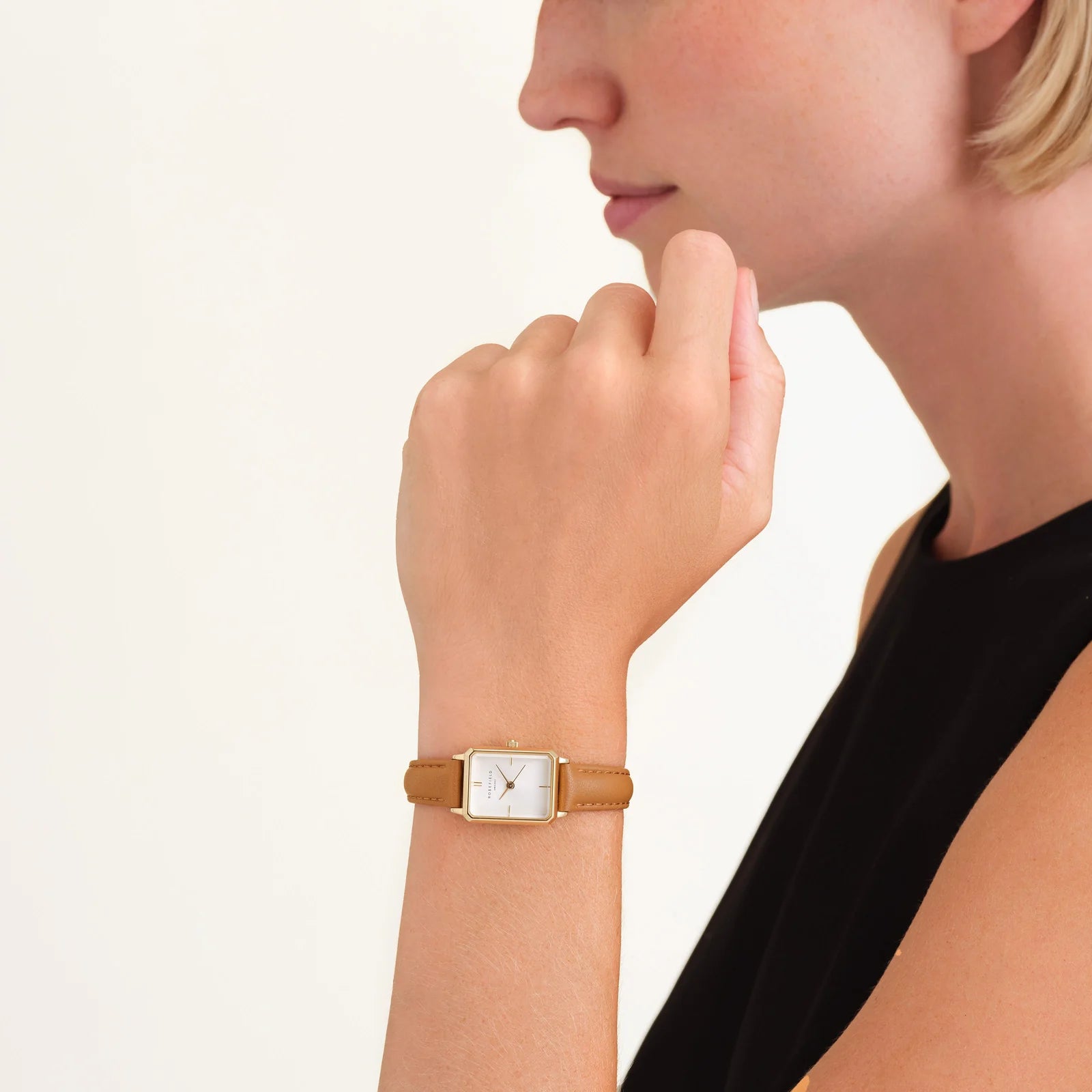Ladies gold octagon-shaped watch with a brown leather band.