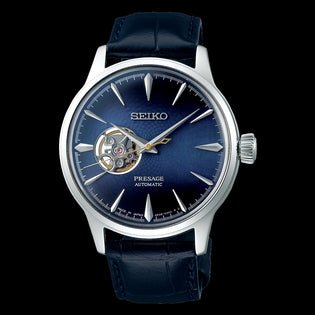 Seiko Presage watch with a blue dial and blue leather strap.  There is an open heart on the dial which shows the inside of the watch