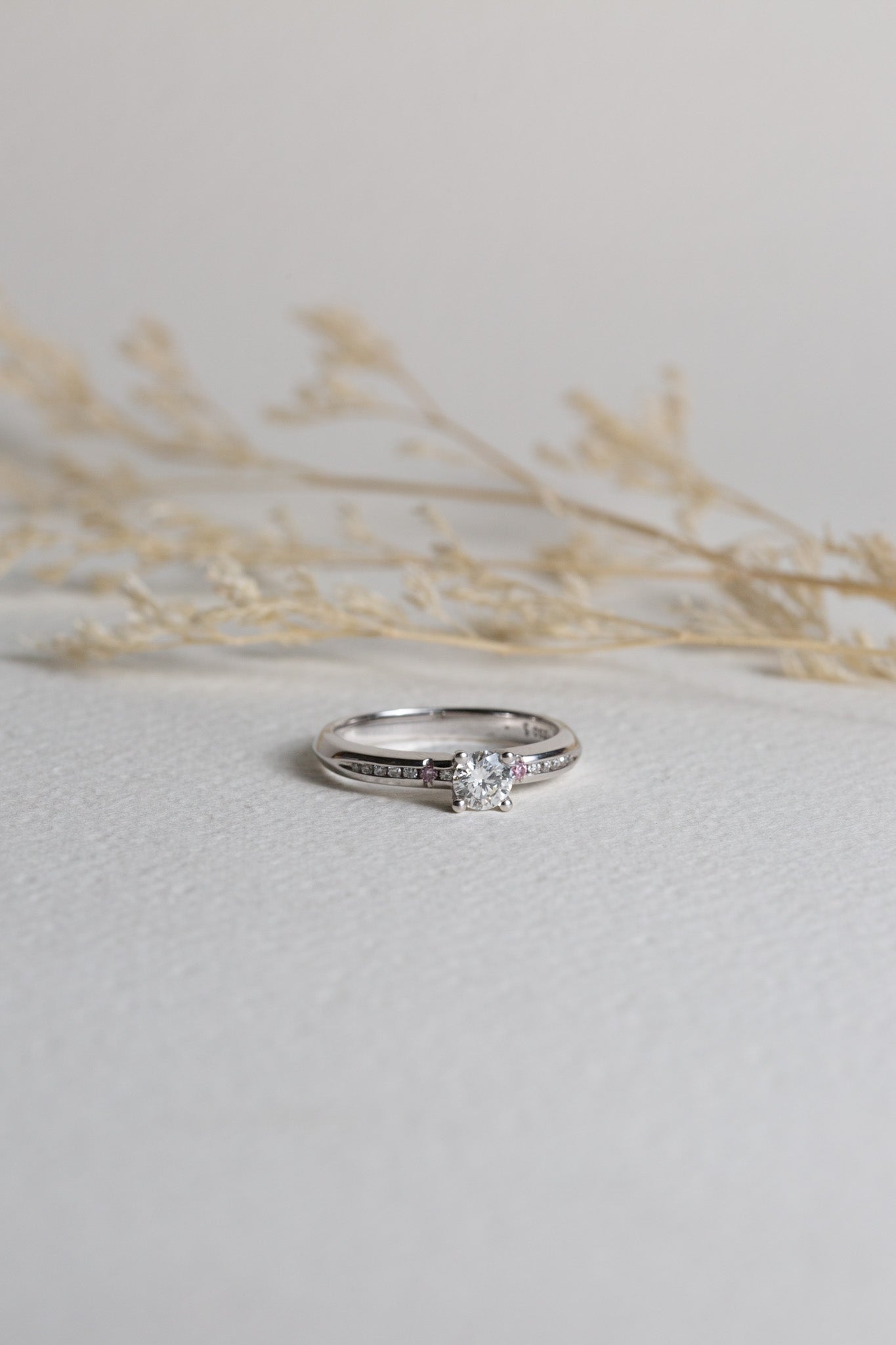 White gold diamond engagement ring, set with natural pink accent diamonds