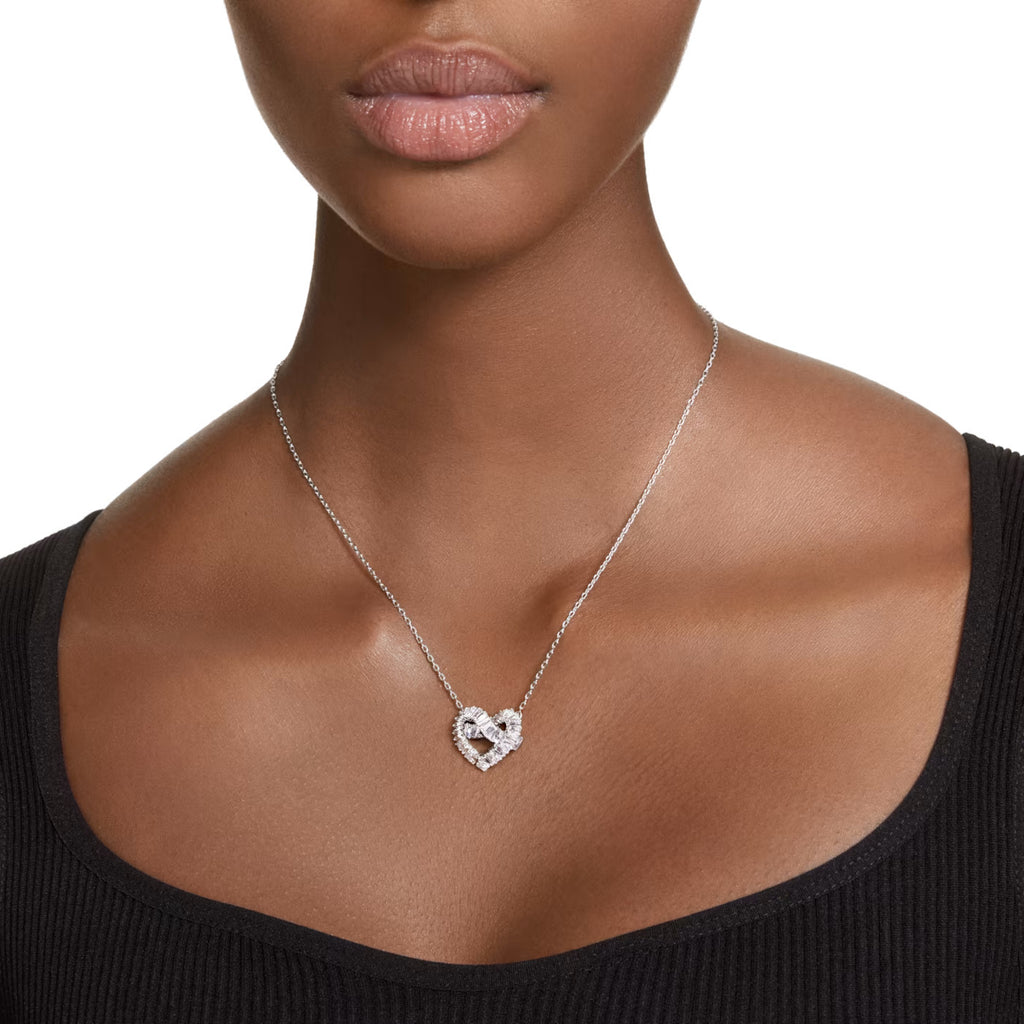 A model is wearing a Swarovski crystal heart neckalce