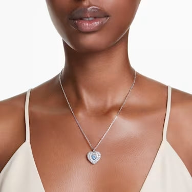 A model is wearing a Swarovski crystal heart necklace