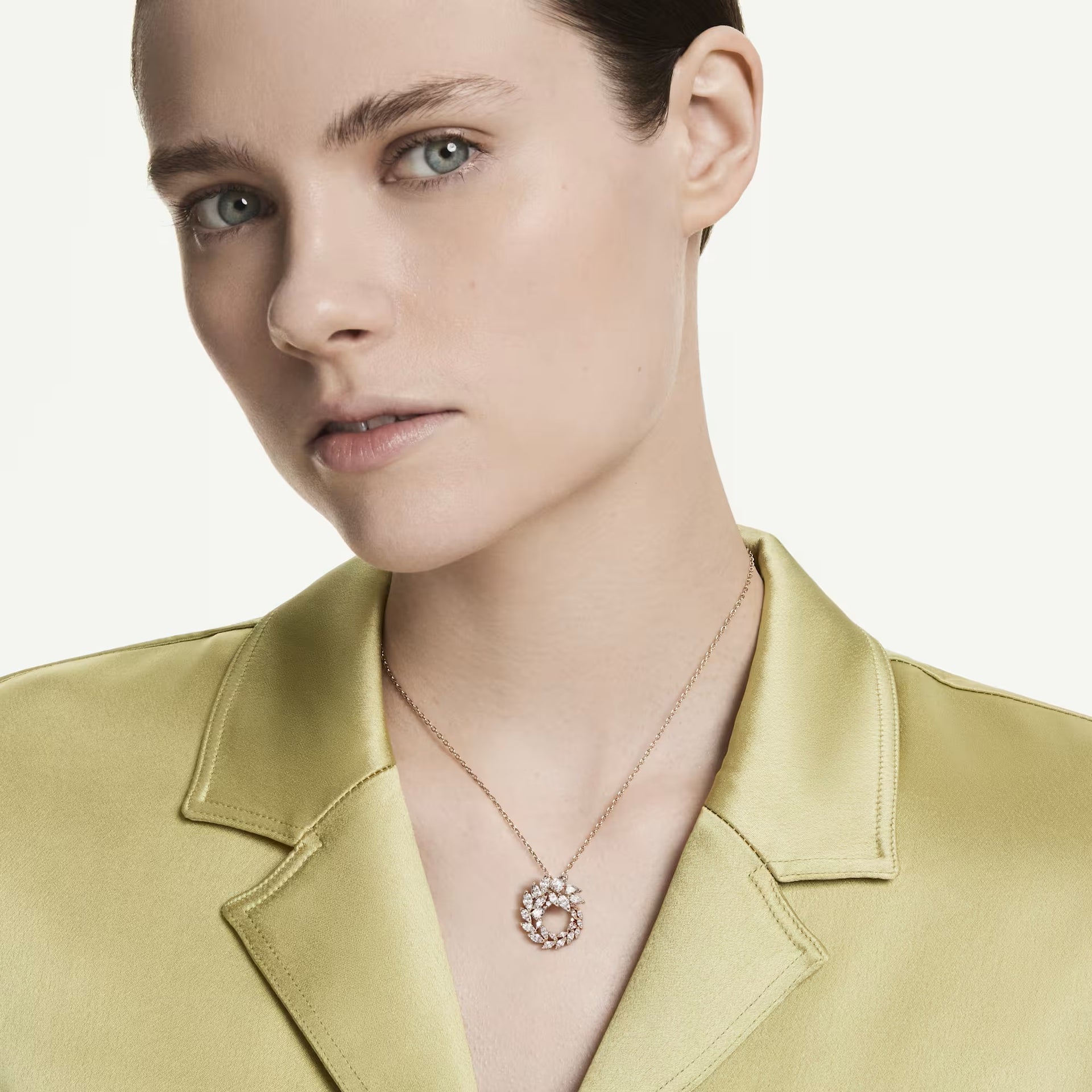 Woman wearing the Swarovski Mesmera pendant in rose gold