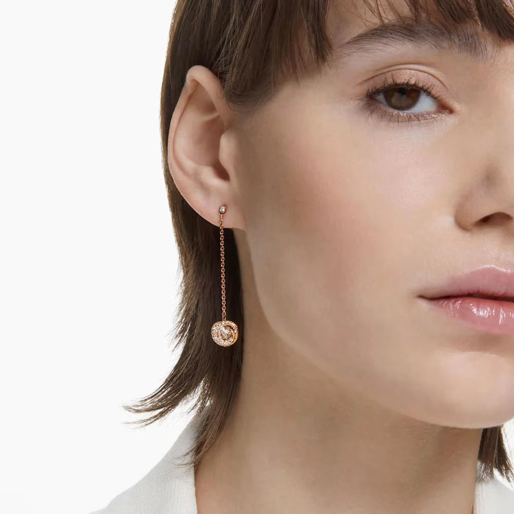 A model is wearing long drop earrings
