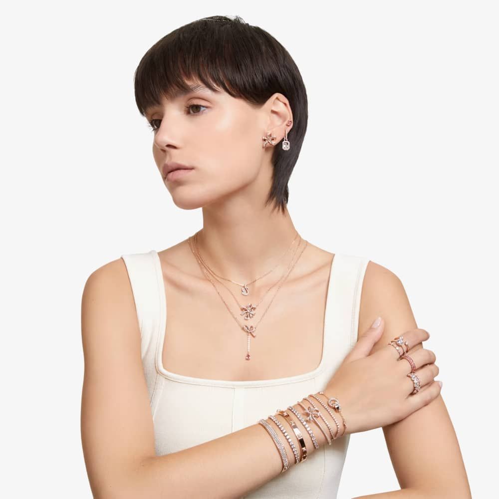 A model is wearing matching earrings, bracelets, and necklaces from the Swarovski Volta Collection