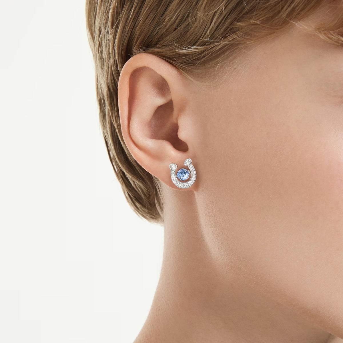 Swarovski Symbolica stud earrings, rhodium-plated horseshoe with blue dancing stone