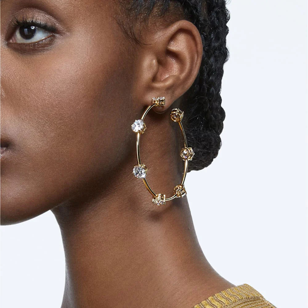 Large gold hoop earrings with Swarovski crystals all around them, worn by a model