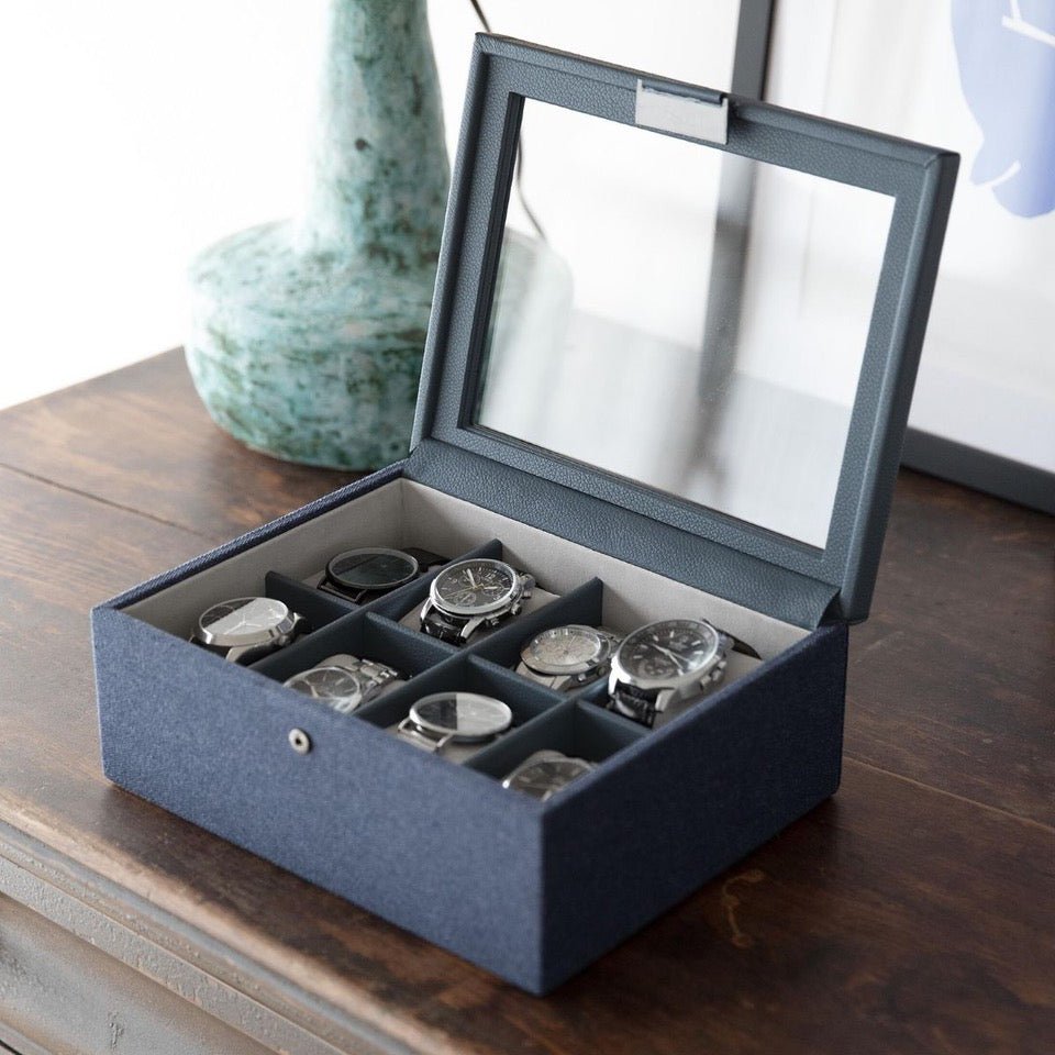 Crafted with a premium faux leather and canvas exterior, this contemporary watch storage box is finished with sleek gunmetal hardware for a stylish, modern look. 